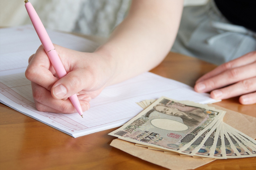 家計簿をつける一人暮らしの女性