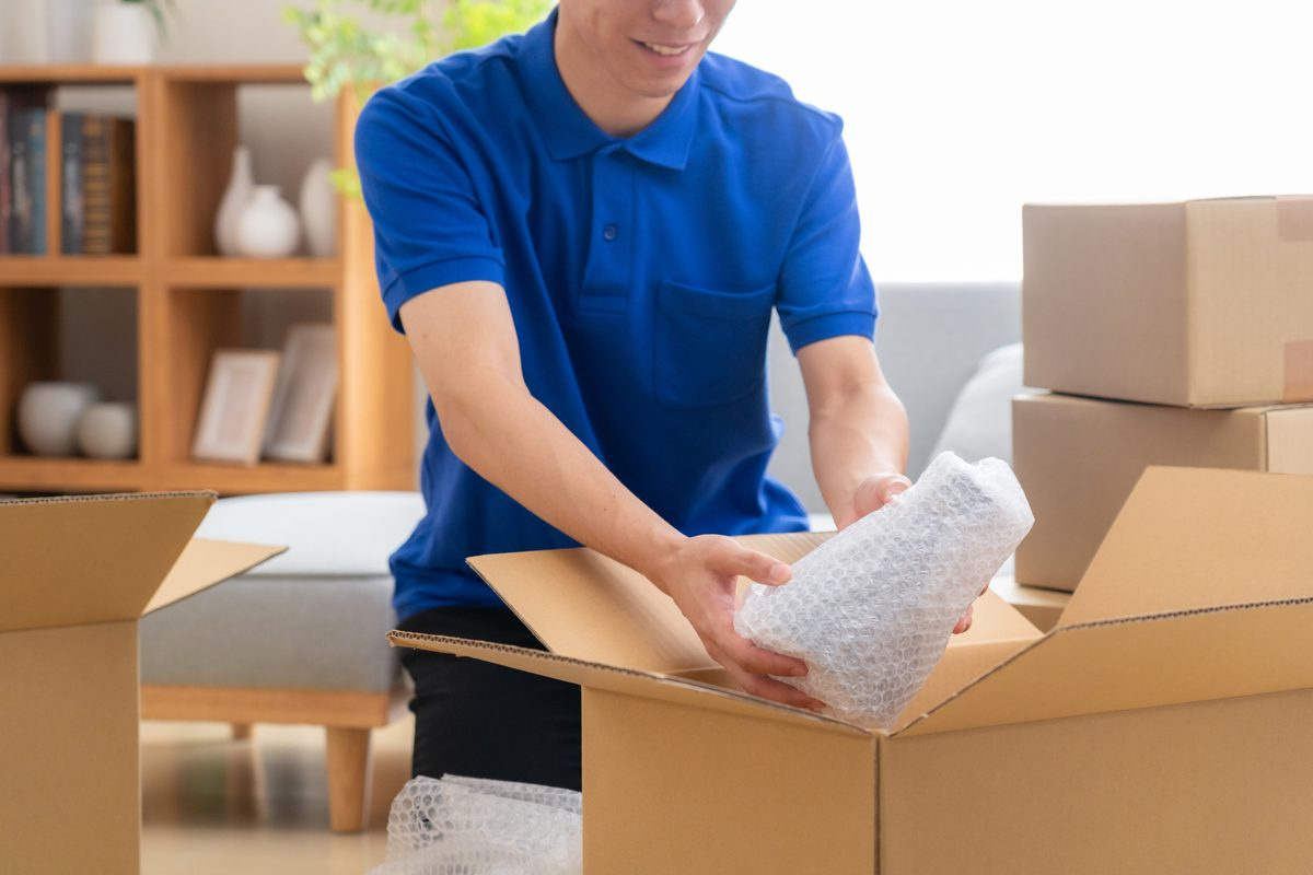 引越しの荷造りをする男性