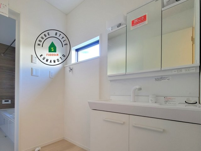 合志市須屋第18-3棟（2号棟）の内観：施工例|毎日使うものだから清潔な空間を保ちたい水回り。洗面にはそんな願いを解消させてくれる収納アイデアが満載です。三面鏡の裏側にはキャビネットが現れ小物から背の高い物まで収納できます。