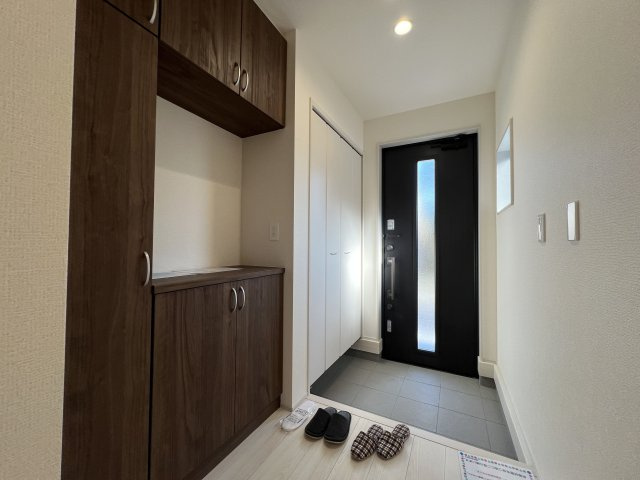 あきる野市野辺　新築戸建全2棟の玄関|折り戸収納＋シューズボックスあり家族の履物が全部しまえるワイドな玄関収納