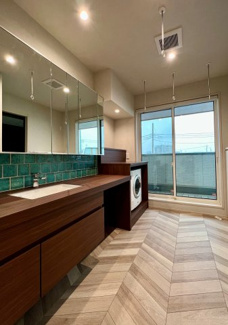 【独立洗面台】 | 越谷大成町 /積水ハウス高級邸宅「IS ROYÉ」/5LDK+2WIC | ホテルのような洗練されたデザインの洗面室。ツートンカラーのタイル、ワイドな鏡、そしてバルコニーに面した設計で、採光・換気も良好。ランドリースペースとしても機能的です。