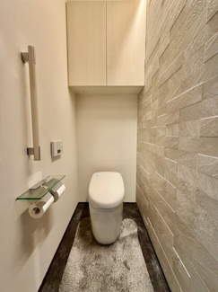 【トイレ】 | 越谷大成町 /積水ハウス高級邸宅「IS ROYÉ」/5LDK+2WIC | ホテルライクな石調アクセントウォールを採用した、清潔感溢れるレストルーム。上質なタンクレストイレと造作収納で、快適な空間を追求しています。