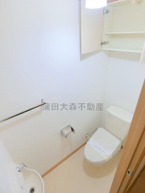 南雪谷ガーデンのトイレ|吊り棚、手洗い場、温水洗浄便座付きのトイレ　