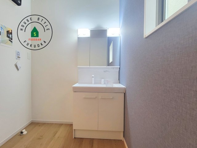 春日市須玖南7丁目第1-3棟（1号棟）の内観：施工例|毎日使うものだから清潔な空間を保ちたい水回り。洗面にはそんな願いを解消させてくれる収納アイデアが満載です。三面鏡の裏側にはキャビネットが現れ小物から背の高い物まで収納できます。