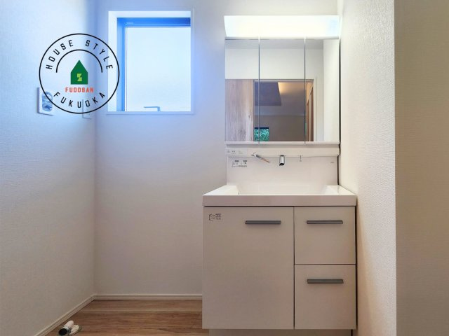 糟屋郡新宮町大字湊第4-2棟（1号棟）の内観：施工例|毎日使うものだから清潔な空間を保ちたい水回り。洗面にはそんな願いを解消させてくれる収納アイデアが満載です。三面鏡の裏側にはキャビネットが現れ小物から背の高い物まで収納できます。