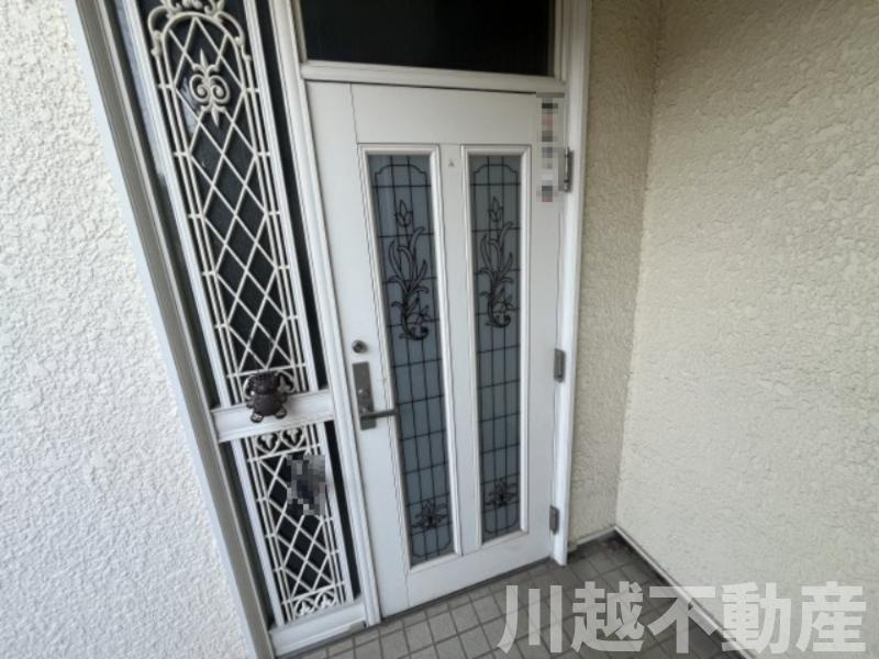 プライベートガーデンとテラスのある家の玄関|装飾デザインが施された白基調の明るい玄関ドア