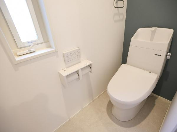 AG-HOUSE 萩原A棟のトイレ|窓があるため通気性に配慮されたトイレです。壁リモコン式で操作しやすく清潔感のある内装が特徴です。シンプルな設計で明るい雰囲気が印象的です。紙巻器も使いやすい位置に設置されています。