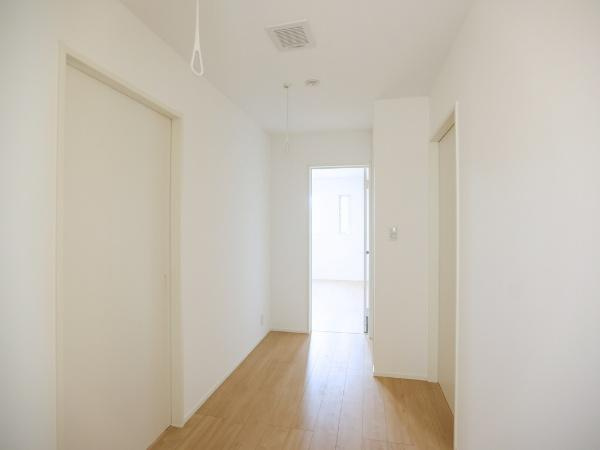 AG-HOUSE 萩原A棟の内装|明るい光が差し込む廊下は清潔感のある雰囲気が広がっています。シンプルなデザインで生活動線がすっきりしています。床の木目がアクセントとなり空間に温もりをプラスしています。