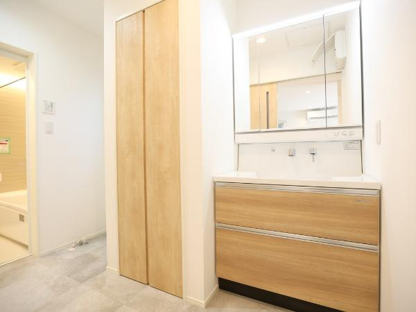 AG-HOUSE 萩原A棟の独立洗面台|洗面台には木目調が取り入れられており空間がスタイリッシュな印象です。ゆとりあるスペースで動線もスムーズです。収納スペースも充実しており使いやすさを感じます。照明が明るく鏡まわりが見やすい設計です。