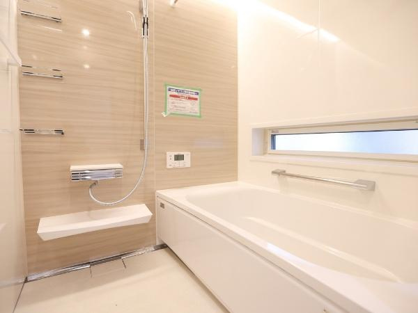 AG-HOUSE 萩原A棟の浴室|明るい色合いのバスルームは清潔感があります。ワイドな浴槽が設置されておりゆったりとしたスペースが確保されています。使い勝手の良いカウンターや手すりが備えられています。
