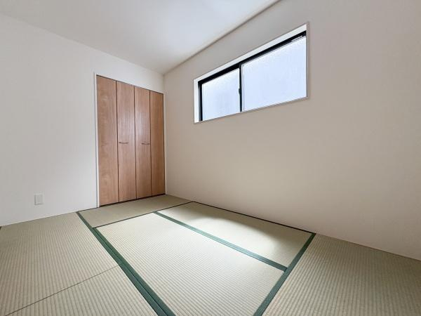 大字鴛野1期1号棟の和室|窓から明るい日差しが差し込み落ち着きのある和室です。シンプルな内装でお手入れもしやすい空間となっています。収納スペースもあり使い勝手が良いです。押入れの扉は木目調で落ち着いた雰囲気を演出しています。