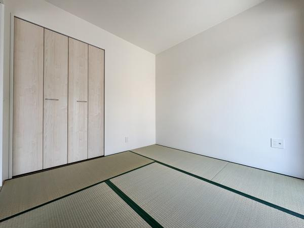 大字鴛野1期2号棟の和室|シンプルなデザインの和室が魅力です。壁や建具の色合いが落ち着いた雰囲気を演出しています。押入れが設置されており収納スペースも確保されています。掃除がしやすい畳敷きですっきりとした印象です。