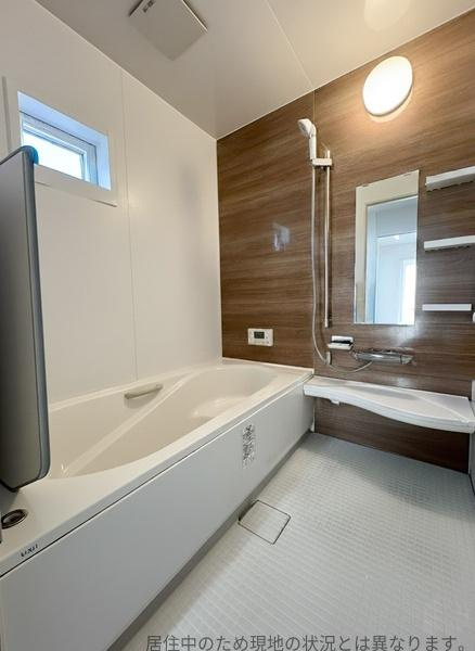 明野南一丁目中古の浴室|浴室は明るい雰囲気で窓があり換気に便利です。ダークウッド調の壁面が落ち着いた印象を与えます。鏡や棚も備わっており整理しやすいデザインです。バスタブはゆったりとしたサイズです。