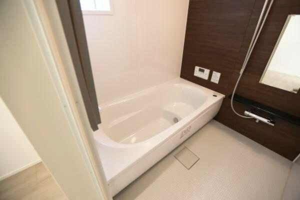 タマタウン青葉台　2号地の浴室|落ち着いた色合いの壁面が特徴的なバスルームです。浴槽はゆったりとしたサイズ感でリラックスできる空間を実現しています。シンプルで清潔感のあるデザインが魅力的です。