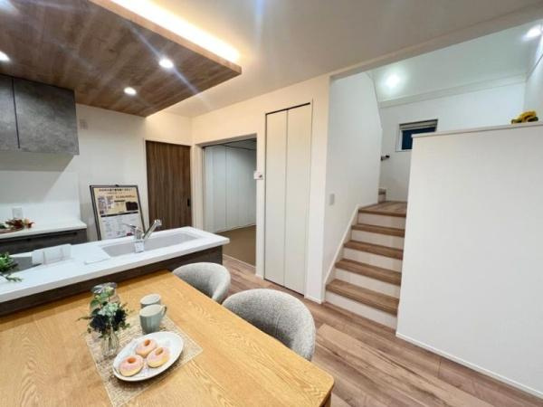 タマタウン坂ノ市3　5号地の居間・リビング|キッチンの上部は間接照明に。スキップフロアとつながります。