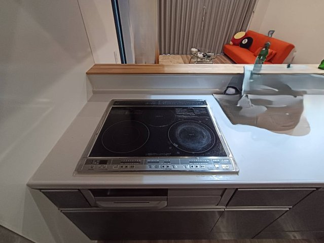 西条市小松町新屋敷甲　中古戸建のキッチン|IHヒーター採用のシステムキッチンは、凹凸が少なくお掃除も簡単。美しい状態を長く保てるので、毎日のお料理が楽しくなります。家族の顔を見ながら作業できる開放的な空間で、会話も弾むはず。