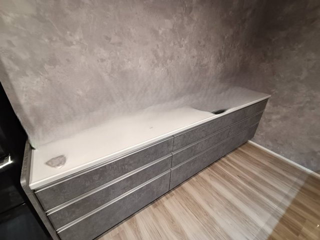 西条市小松町新屋敷甲　中古戸建のキッチン|キッチンと質感を統一したカップボードは、空間に洗練された一体感を生み出します。十分な横幅があるため、電子レンジや炊飯器などの家電を並べて置いても余裕があり、効率的な調理動線で家事時間を短縮できます。