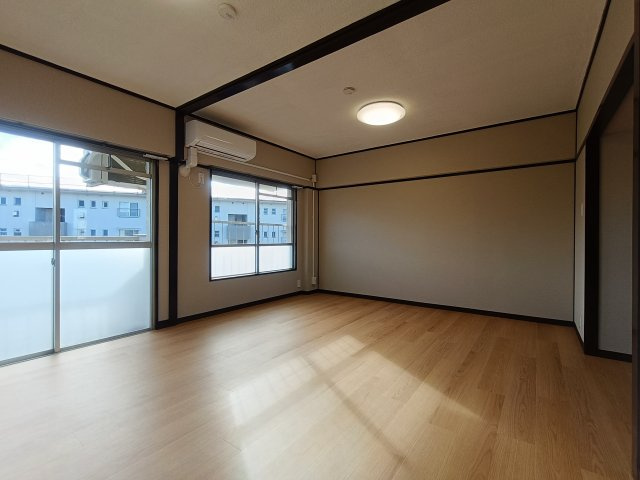 みさと団地13街区15号棟の居間・リビング|柔らかな色合いのフローリングと清潔感の溢れるクロスが明るい空間を創り出しているリビングダイニング