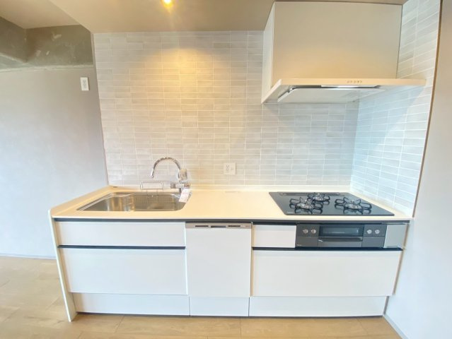 京都上京ハウスのキッチン|食洗機付きのキッチンです。白色のキッチンタイルが綺麗な仕上がりになっています。