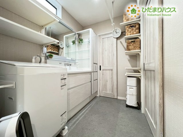 熊谷市原島　中古一戸建ての脱衣所|洗剤やタオルを整理しやすい棚が備え付けられた機能的な洗面スペースです！洗濯機からサンルームへの動線もスムーズで家事効率がアップします。大きな鏡のある洗面台は朝の忙しい身支度時間も快適にしてくれますね♪