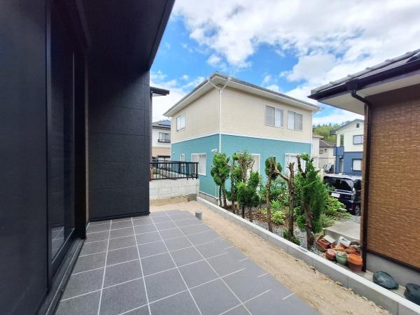 AG-HOUSE　梅が丘　A棟のバルコニー|タイル貼りのバルコニーは広めの設計となっております。手入れのされた植栽が印象的です。隣家との距離も程よく開放感があります。空が広く感じられる眺めです。バルコニー部分の動線も確保されています。