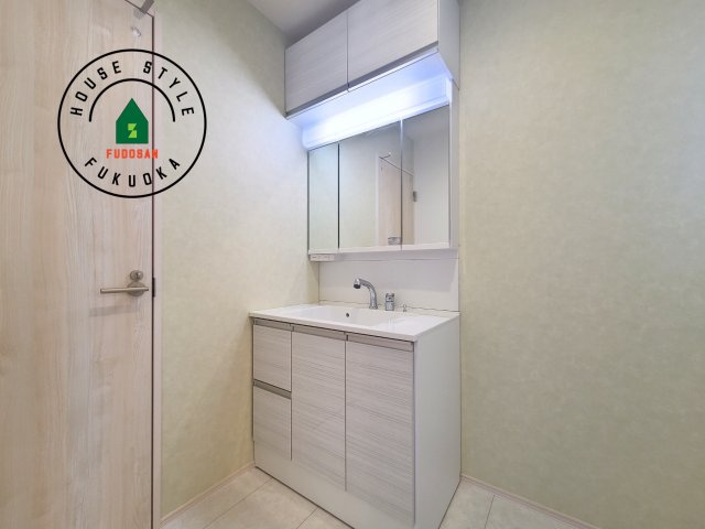 福岡市城南区七隈3丁目第1-3棟（3号棟）の内観：施工例|毎日使うものだから清潔な空間を保ちたい水回り。洗面にはそんな願いを解消させてくれる収納アイデアが満載です。三面鏡の裏側にはキャビネットが現れ小物から背の高い物まで収納できます。