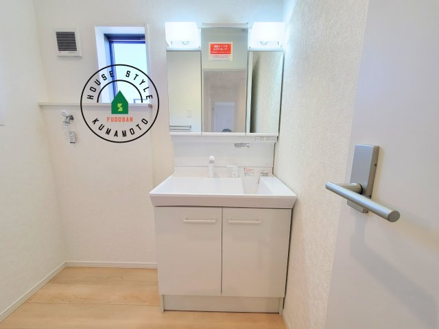 熊本市北区植木町岩野第1-2棟(1号棟)の内観：施工例|毎日使うものだから清潔な空間を保ちたい水回り。洗面にはそんな願いを解消させてくれる収納アイデアが満載です。三面鏡の裏側にはキャビネットが現れ小物から背の高い物まで収納できます。