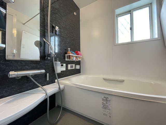 伊川谷町有瀬戸建の浴室|【浴室】
モノトーン配色がスタイリッシュな印象。シャワーはお好きな高さに固定できるスライドバータイプです。窓付きのため、入浴後や掃除の際に気軽に換気できます。