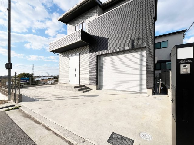 堺市西区戸建の外観|西側は高低差があり、東側は隣地駐車場、南向きの為に陽当たりが良く、風通しも良い状態です。