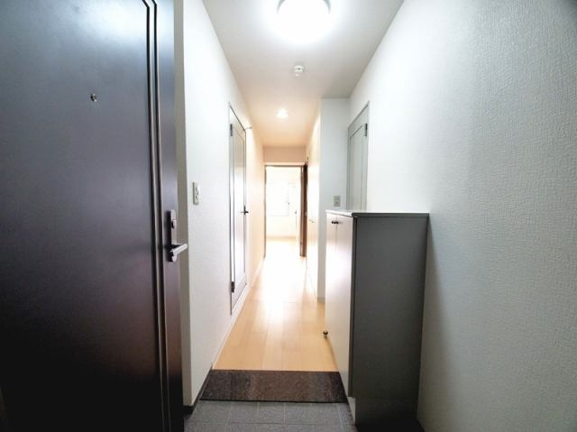 高知市九反田　中古マンションの玄関|家族の靴もたっぷり収納できる玄関。廊下まで光が届く明るい設計で、毎日の出入りが快適です。