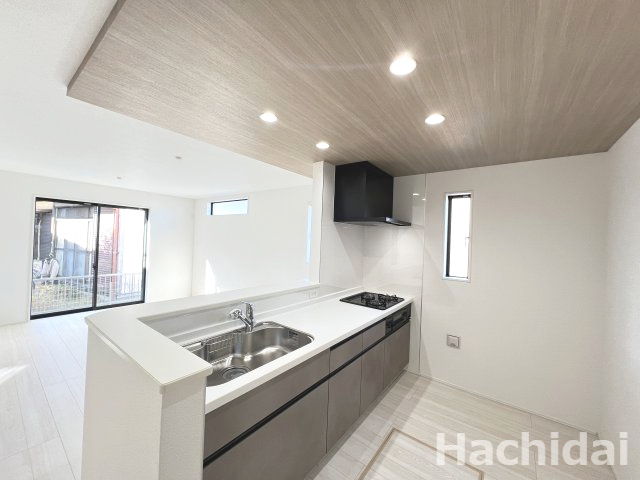 高浜市呉竹町4期2棟　新築一戸建のキッチン|木目の折り上げ天井で天井が高く見え、広々とした印象になります。