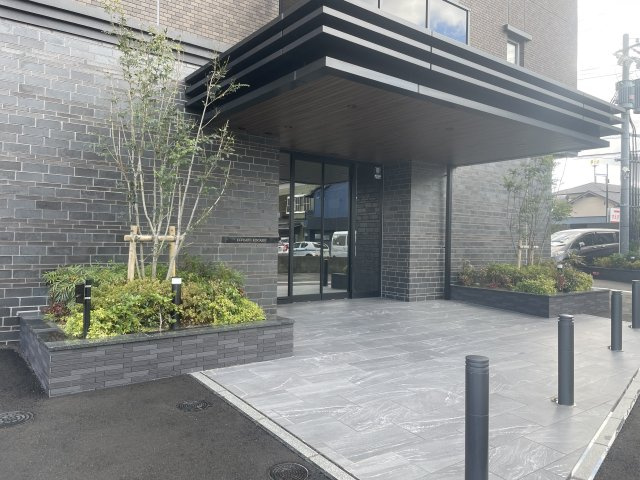 オーヴィジョン古賀駅のその他共用部分|緑の植栽が穏やかに迎える、落ち着いた色合いの外観です。