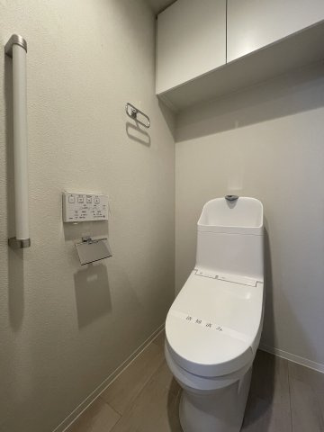 オーヴィジョン古賀駅のトイレ|温水洗浄便座付トイレ。収納に便利な吊戸棚付き。