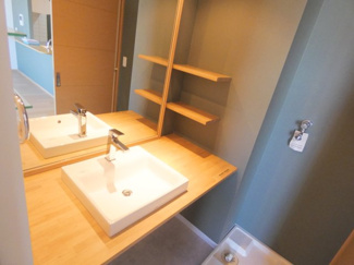 【洗面所】 | クオス小田原栄町 | 【ベッセル式ボウルのモダンな洗面空間】 
木目調のカウンターにスクエア型の洗面ボウルを配した、ホテルライクなデザイン。オープンシェルフも備わり、見せる収納でお洒落な空間を演出できます。