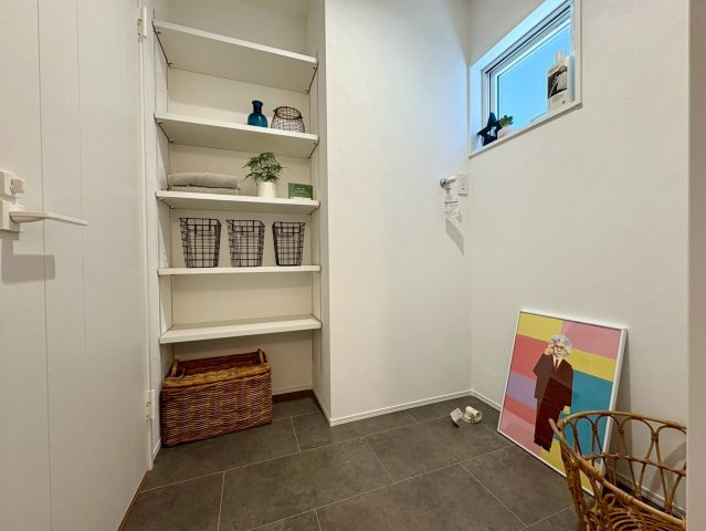 南国市大そね甲　中古一戸建ての玄関|可動棚付きで収納力のあるの脱衣室。タオルや着替え、ランドリー用品をすっきり整理でき、使い勝手の良い空間です