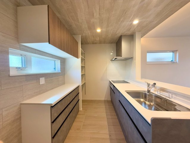 南国市田村乙 中古一戸建のキッチン|背面収納＋パントリー＋広々カウンターの充実キッチン。家事が驚くほどスムーズに。