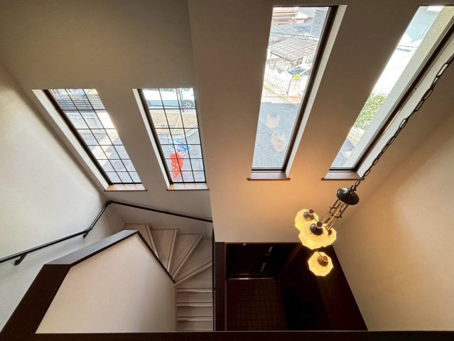 奈良市押熊町の内装|2階からの玄関眺めです。窓付きでより開放感が感じられます。ペンダントライトも映えます。