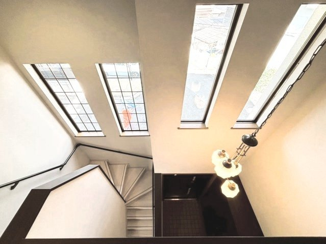 奈良市押熊町の内装|2階からの玄関眺めです。窓付きでより開放感が感じられます。ペンダントライトも映えます。