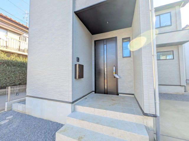 守谷市松ケ丘5期　新築戸建　1号棟の玄関|お洒落な玄関ドアと洗練された外壁デザイン。家の顔にふさわしい上質な佇まいで、ご家族やお客様を迎えます。