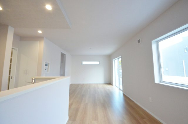 八木八丁目の居間・リビング|窓の多いリビング空間。オープンタイプの対面式キッチンでリビングが隅まで見渡せます。キッチンにいながら小さなお子様にも目が届き安心です。