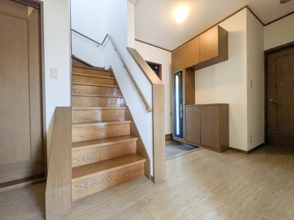 梅が丘2丁目　戸建ての内装|玄関からすぐに階段があり動線がシンプルです。木目の温かみあるデザインで統一感があります。収納スペースもしっかり確保されています。明るい照明で空間が広く感じられます。各部屋へのアクセスも便利です。