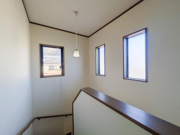 梅が丘2丁目　戸建ての内装|階段スペースには3つの窓があり明るさをしっかり確保できます。壁や天井も白を基調としており清潔感のある印象です。手すりも付いていて安全面にも配慮されています。