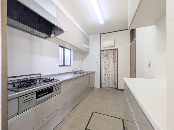 梅が丘2丁目　戸建てのキッチン|広々としたキッチン空間が魅力です。窓があり明るい印象を与えます。収納スペースが豊富で整理しやすい構造です。シンプルなデザインが清潔感を感じさせます。