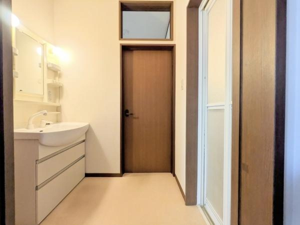 梅が丘2丁目　戸建ての独立洗面台|洗面台が広々としており収納スペースも豊富に確保されています。清潔感のある内装で使いやすさを感じられます。明るい照明が設置されており日常の身支度にも便利です。扉付きでプライベートな空間が保たれています。