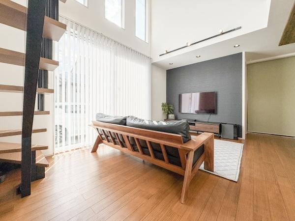 角子原　戸建ての居間・リビング|明るい光が差し込むリビングは開放感を感じられます。大きな窓と高い天井が空間を広く演出しています。シンプルな内装が落ち着いた印象を与えます。木目調フローリングが温かみを感じさせます。