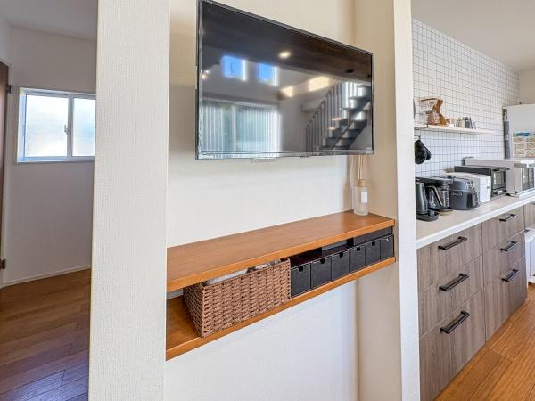 角子原　戸建ての居間・リビング|リビングの壁面にはテレビが設置されておりすっきりとした印象です。造り付けの棚には収納スペースも確保されています。開放感のある空間で家具の配置もしやすいです。内装はシンプルで使い勝手が良いデザインです。