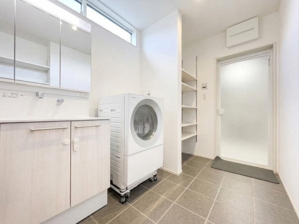 角子原　戸建ての独立洗面台|明るさが確保された洗面所で洗濯機や収納棚が使いやすいレイアウトです。床はお手入れがしやすいタイル仕様となっています。窓から自然光が差し込むため快適な空間となっています。