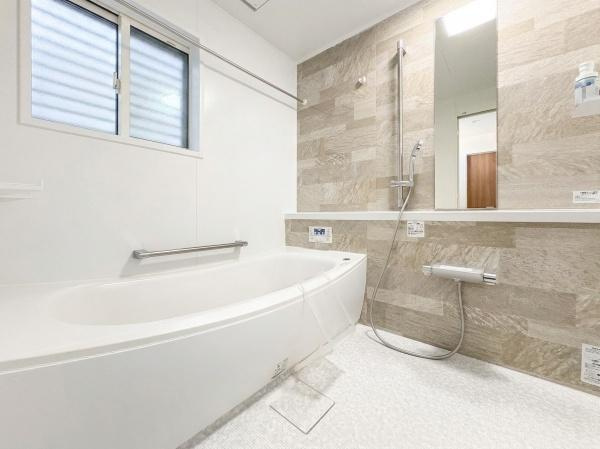 角子原　戸建ての浴室|広々としたバスタブが特徴的な空間です。壁面のアクセントパネルが落ち着いた雰囲気を演出しています。浴室乾燥用の物干しが備わっているため使い勝手が良いです。窓があり明るさと換気にも配慮されています。