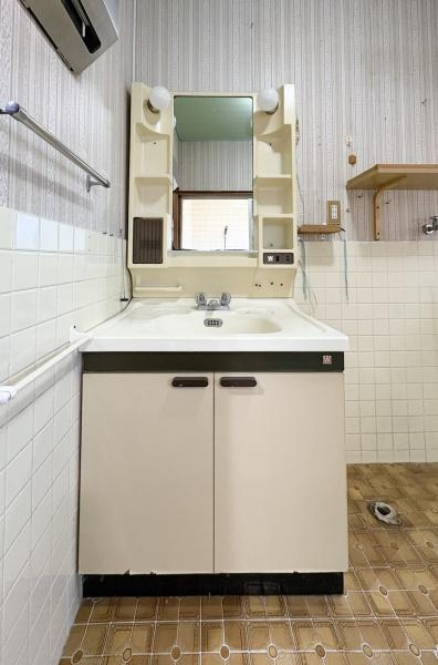 緑が丘4丁目中古の独立洗面台|収納棚が付いた洗面台です。ミラー周りには小物が置けるスペースがあります。タイル張りの壁が特徴的です。床のデザインにもこだわりを感じます。全体的にシンプルで使いやすい印象です。