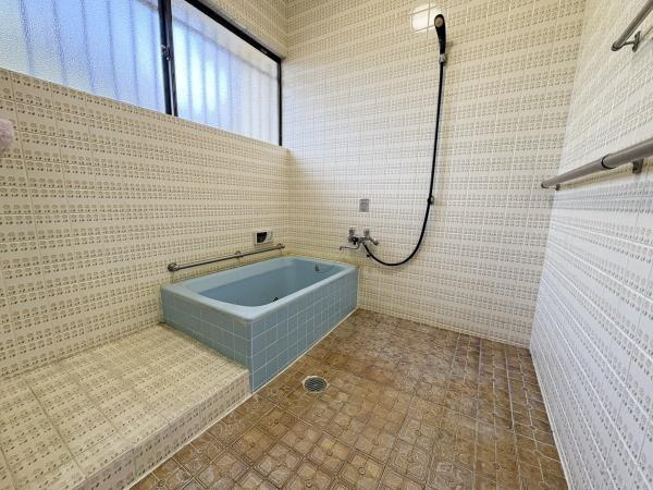 緑が丘4丁目中古の浴室|広々とした空間が特長の浴室です。タイル張りで掃除がしやすく換気に便利な窓も設置されています。手すりも設けられており使いやすさが感じられます。